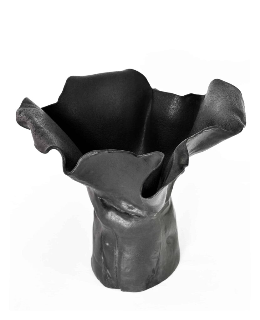 A matte black ceramic vase from the "Black Magnolia" series, its sculpted form and flared petal rim evoke refined organic artistry. , an original work available at MÍRAME Fine Art.