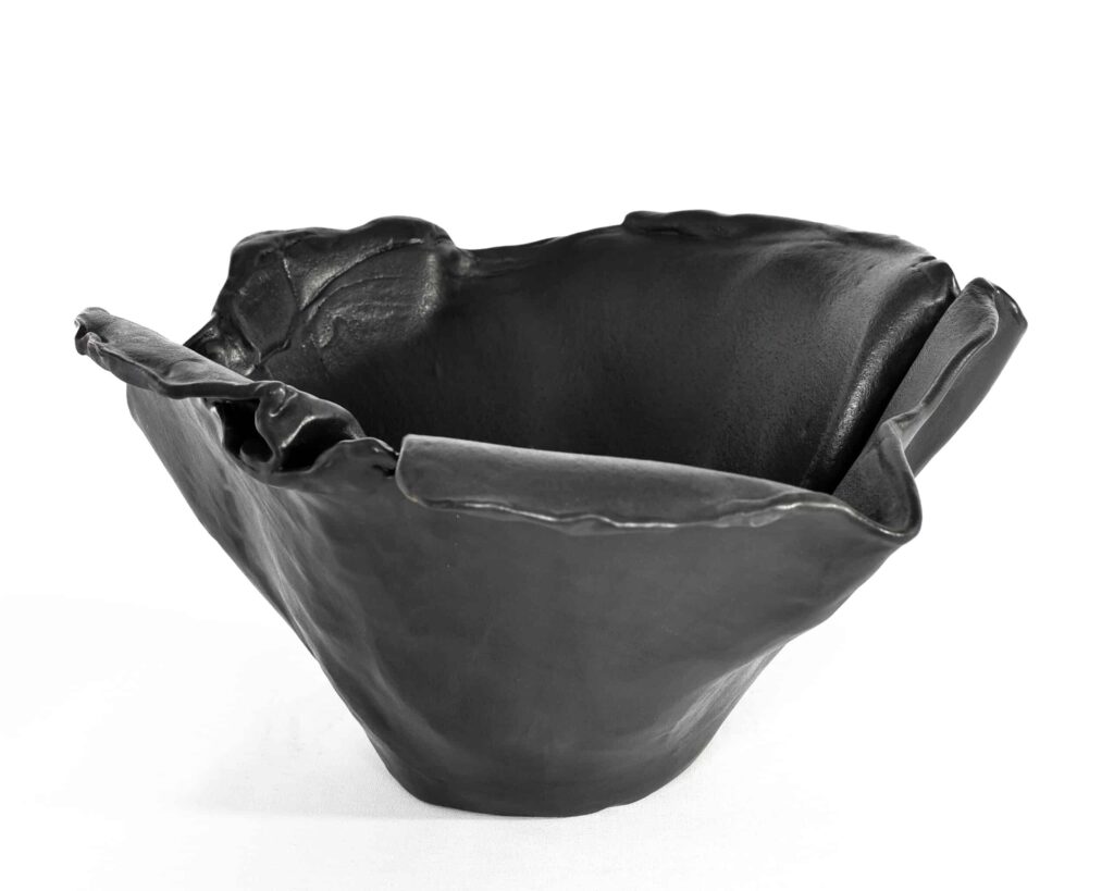 Presented from the "Black Magnolia" series, this matte black ceramic bowl boasts fluid, undulating edges and an artfully sculpted form. , an original work available at MÍRAME Fine Art.