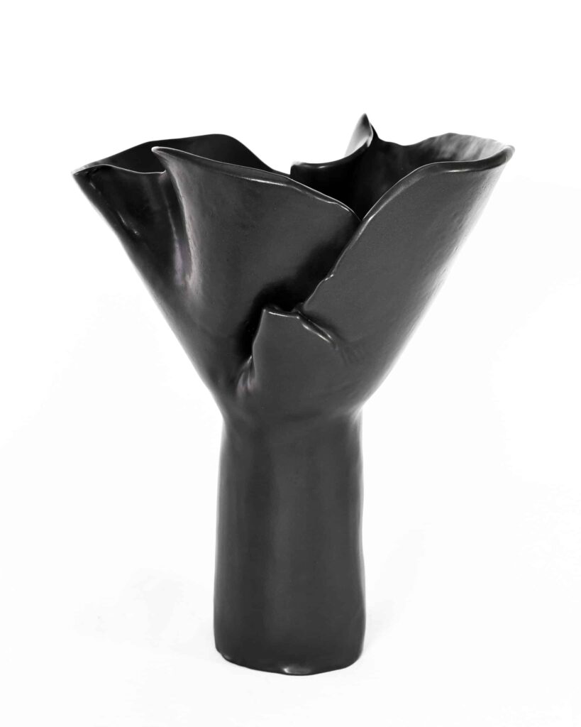 A black ceramic vase from the "Black Magnolia" series, its lustrous finish and sculpted, petal-like forms evoke refined elegance. , an original work available at MÍRAME Fine Art.