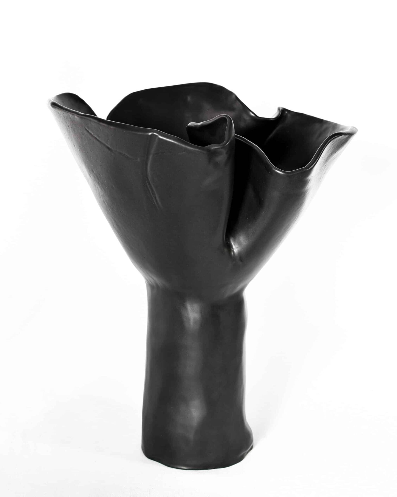 This black ceramic from "Black Magnolia" presents a tall, flared vessel with a folded rim—its glossy, organic form captivates. , an original work available at MÍRAME Fine Art.