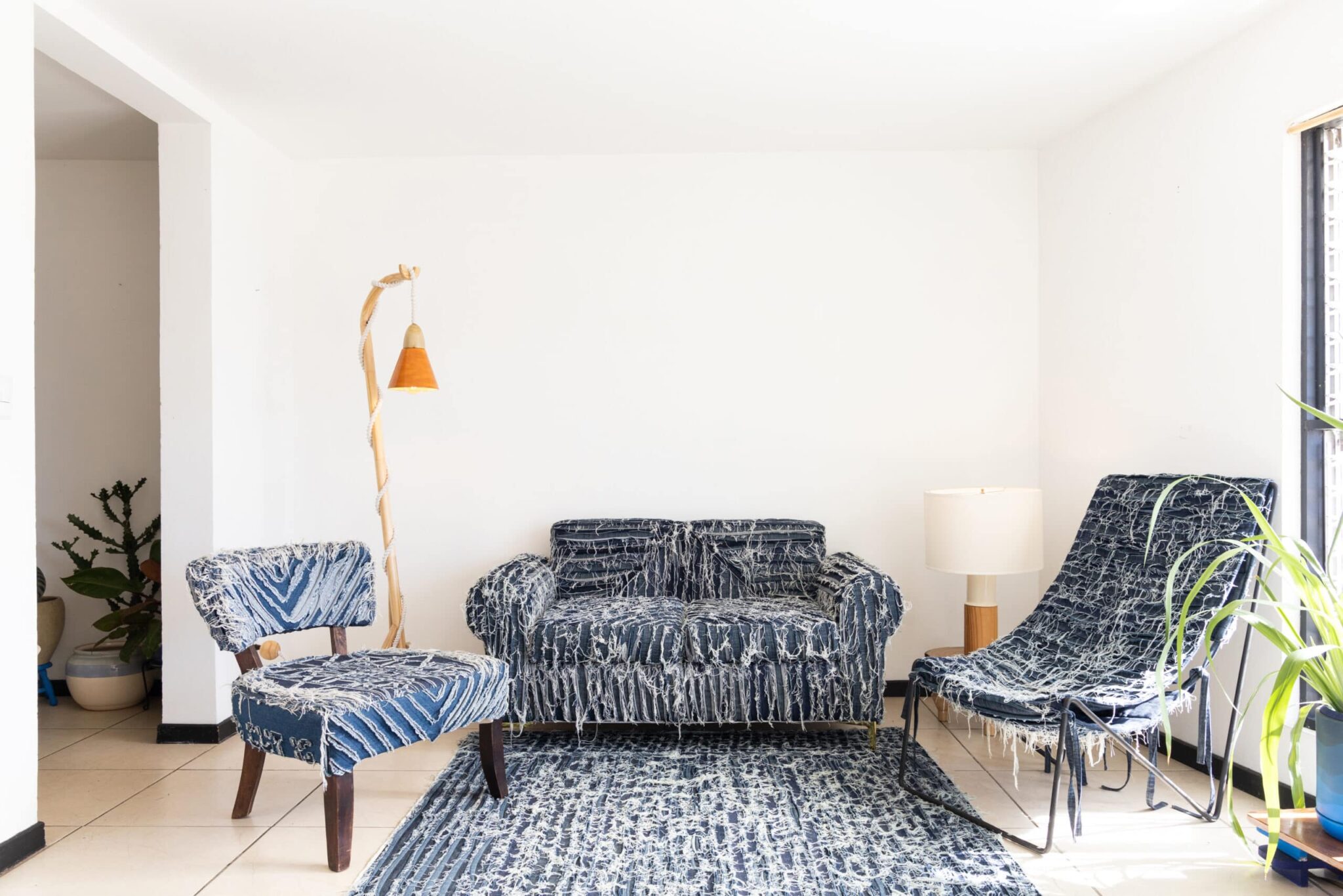 An inviting living space showcases blue patterned Olimpia chairs, a matching loveseat and rug, accented by curated decor and greenery. , an original work available at MÍRAME Fine Art.