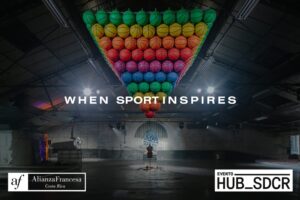 Dark warehouse with colourful balls advertising the When Sport Inspires exhibition.