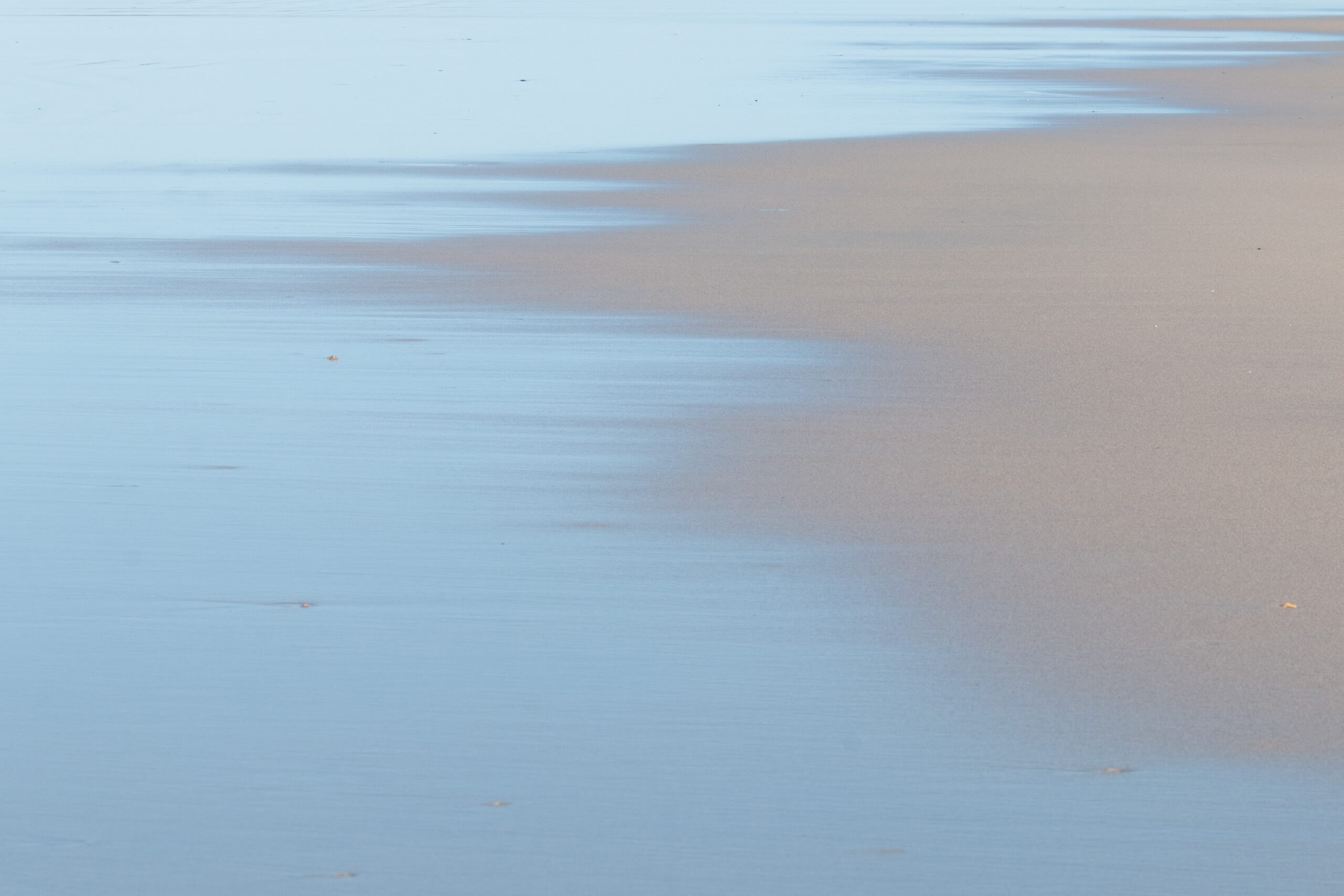 Beach and Ocean photography, showcasing a mindful photographic experience, by Leonardo Ureña. This tranquil image features silvery blue water lapping onto sand.