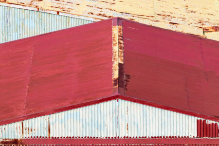 Red and white urban photography of geometric red rooftops, by Leonardo Ureña.
