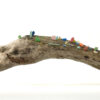 A wooden trunk sculpture of driftwood with colourful pieces of plastic embedded in the wood.