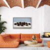 Seed pod painting hanging on the wall of a contemporary living space, with orange couch and textured ceiling.
