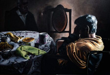 An emotive still life portraiture painting featured in a Jesus Mejia exhibition of a figure sitting at a table, a hand held to her head in grief. The still life scene creates a sense of loss and the striking contrasts of light and shadow create poignancy and increased sadness.