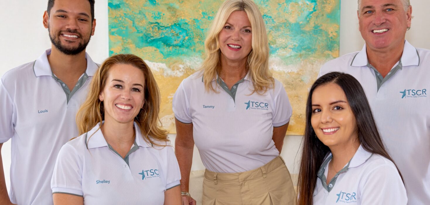 Two men and three women in matching white t-shire uniform smile at the camera. The team of Tammy Sells Costa Rica.