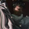 Dark, close-up portrait painting of a boy or man sleeping with fabric and orbs surrounding the face. Morpheus and his Stars.