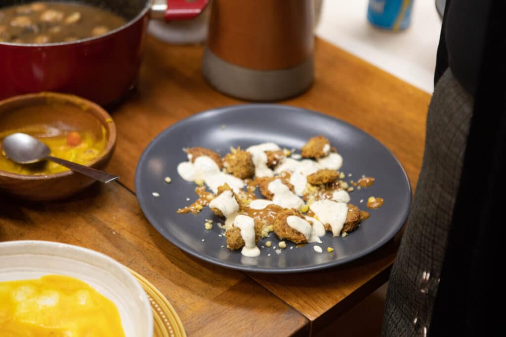 Costa Rican artist Carlos Fernández preparing materials during an activation performance, arranging vegetables on a table as part of a Latin American art exhibition focused on ecology and community engagement.