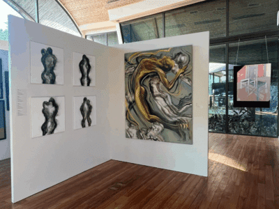 Paintings hanging on white walls as part of Peninsula Papagayo Art week at Andaz, 2024.