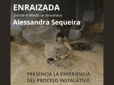 Alessandra Sequeira working on her installation 'Enraizada' (Donde el Miedo se desvanece), weaving organic materials including dried grasses and natural fibers on a gallery floor