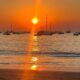 This evocative composition captures the serene majesty of a Guanacaste coastal sunset, a huge part of Guanacaste culture. The scene unfolds with the setting sun casting a radiant orange hue across a tranquil sea, where numerous boats appear as silhouettes anchored near the horizon. Gentle reflections dance upon both water and sand in the foreground, infusing the canvas with a luminous warmth. The overall atmosphere exudes tranquility and reverence for cherished cultural traditions that celebrate Costa Rica’s coastal landscapes and languid, peaceful evenings. , an original work available at MÍRAME Fine Art.